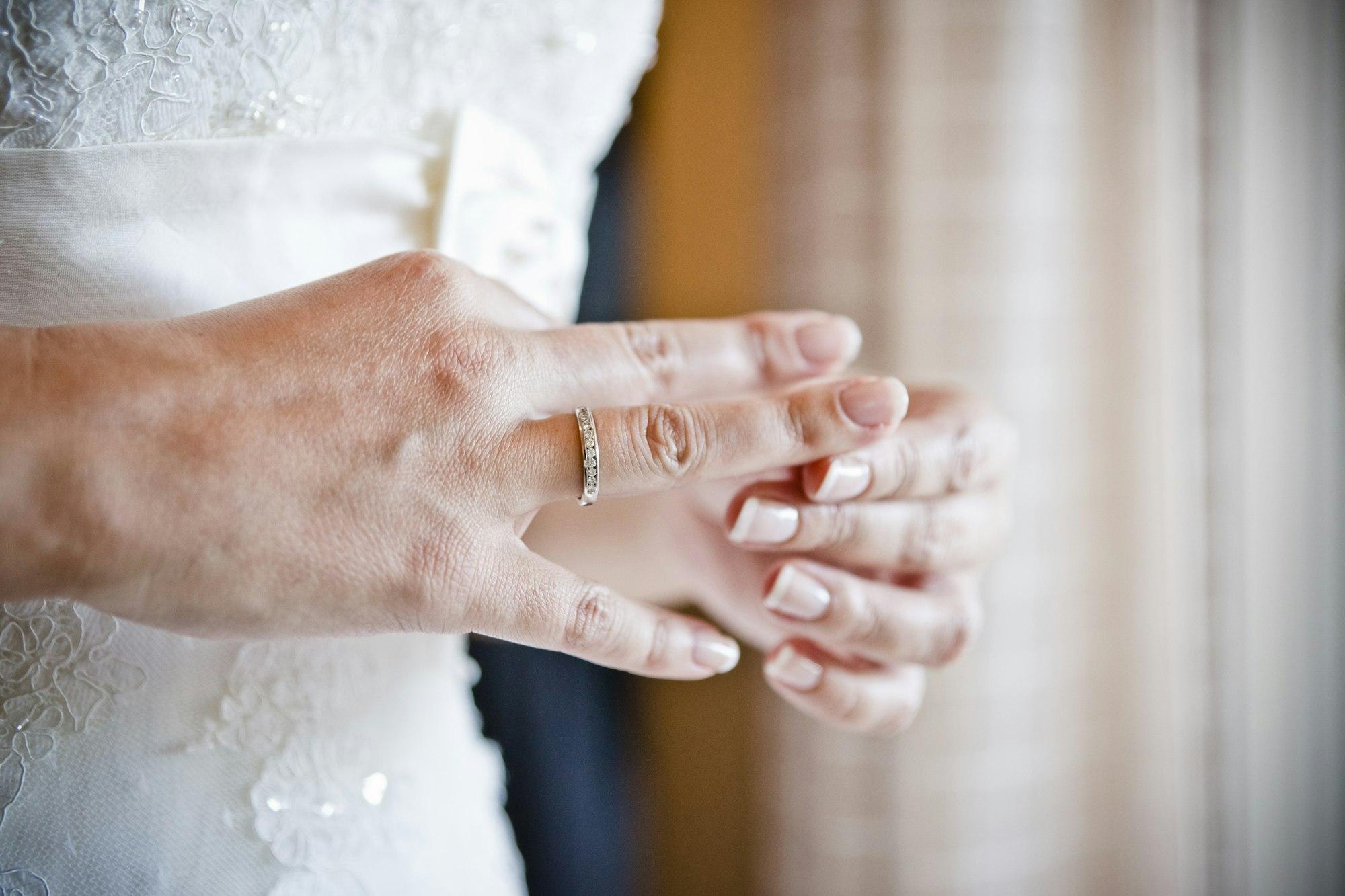 Hnd of a girlfriend fiddling with her wedding ring, concept of divorce and indecision.